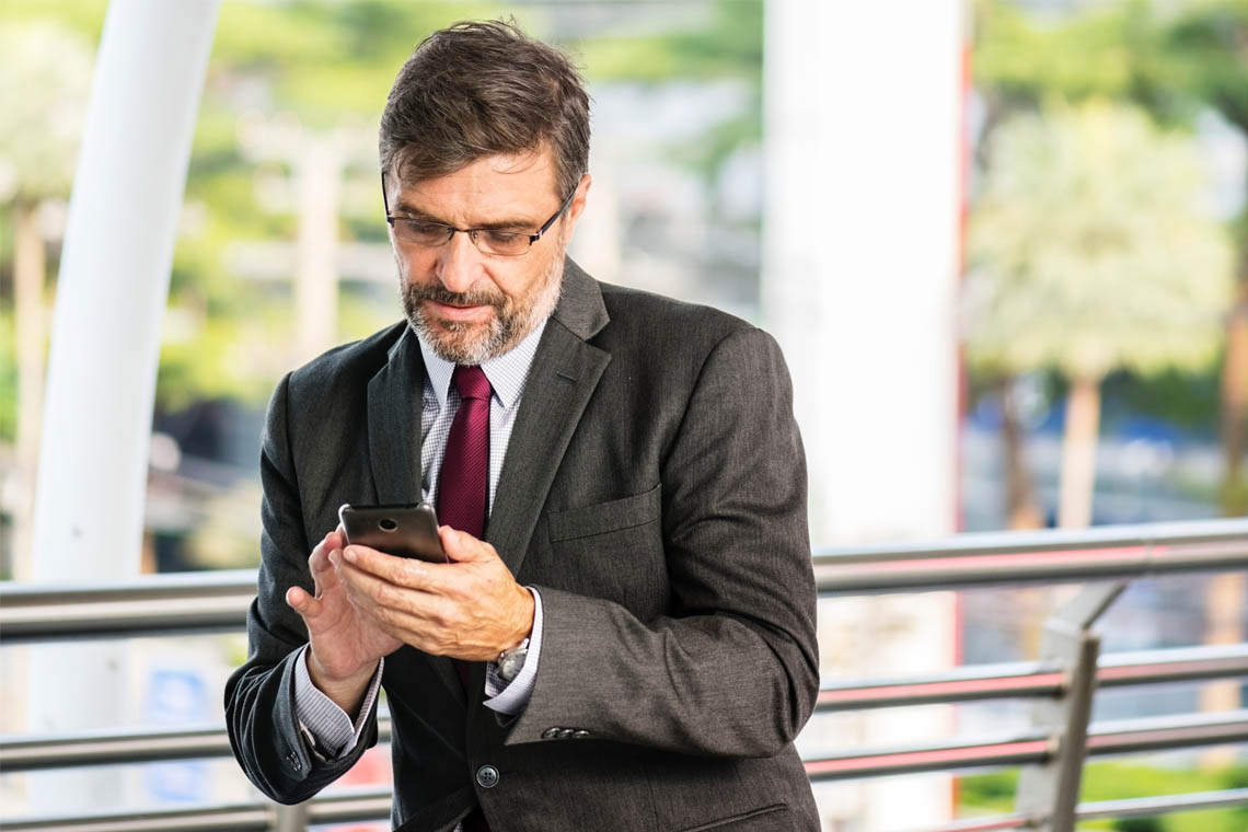 Mann liest auf seinem Smartphone